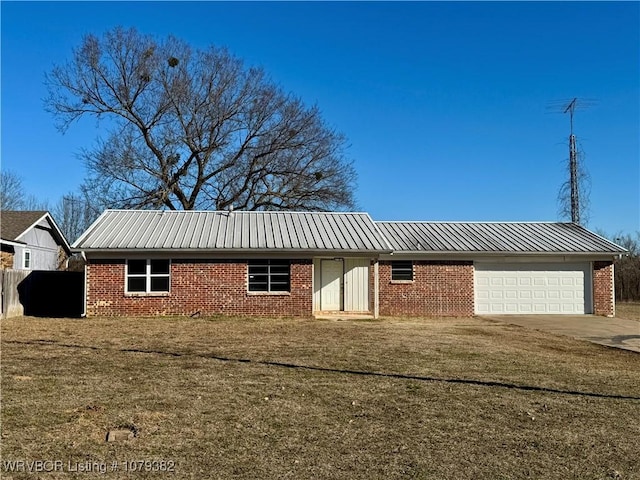 ranch-style home with a garage, brick siding, concrete driveway, metal roof, and a front yard