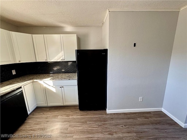 kitchen featuring a textured ceiling, light wood-style flooring, white cabinets, black appliances, and tasteful backsplash