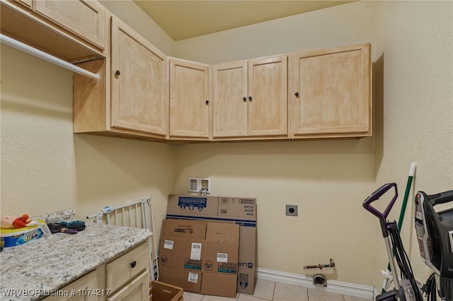 washroom featuring cabinets, washer / dryer, and light tile patterned flooring