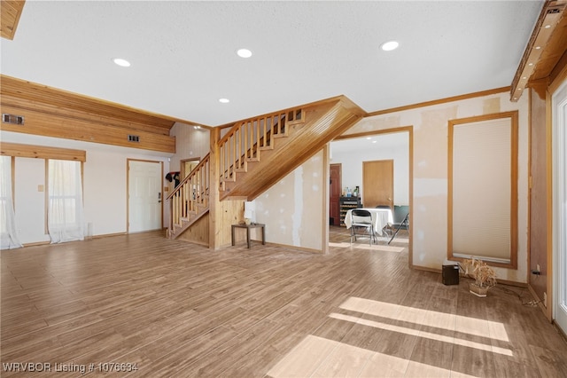 unfurnished living room featuring crown molding and light hardwood / wood-style flooring