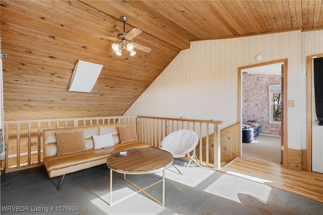 sitting room featuring ceiling fan, carpet floors, wooden ceiling, and lofted ceiling with skylight