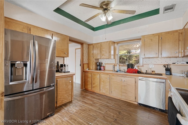 kitchen with sink, light hardwood / wood-style floors, a textured ceiling, and appliances with stainless steel finishes