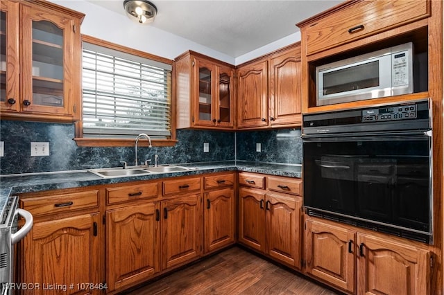 kitchen featuring dark hardwood / wood-style floors, tasteful backsplash, stove, oven, and sink