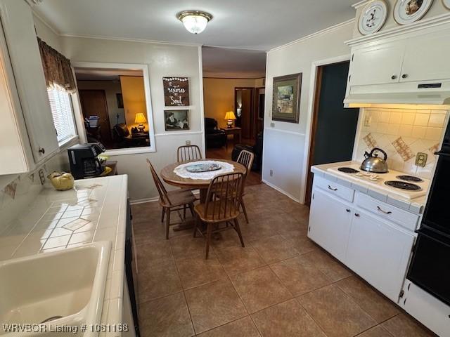 216 Jefferson Dr, Charleston, AR 72933 - tiled dining space with crown molding and a sink