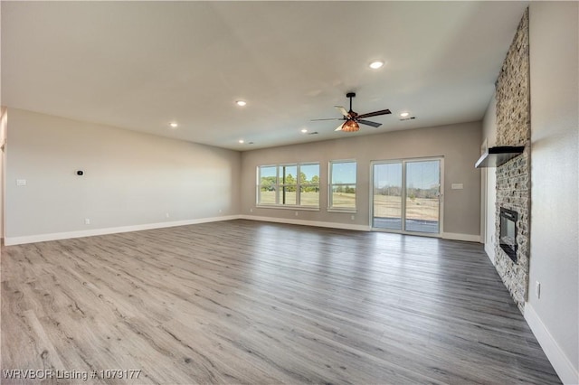 unfurnished living room with a fireplace, recessed lighting, a ceiling fan, wood finished floors, and baseboards