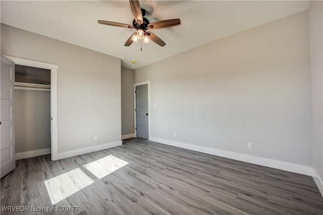 unfurnished bedroom featuring light wood-type flooring, a ceiling fan, baseboards, and a closet