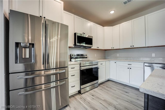 kitchen featuring light wood finished floors, stainless steel appliances, recessed lighting, visible vents, and white cabinets