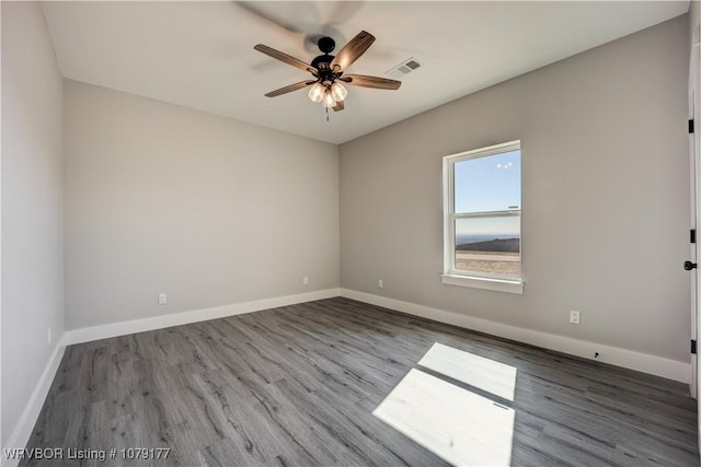 unfurnished room featuring visible vents, ceiling fan, baseboards, and wood finished floors