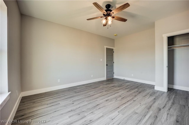 unfurnished bedroom with a closet, light wood-type flooring, a ceiling fan, and baseboards