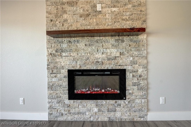 details with a fireplace, baseboards, and wood finished floors