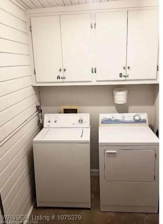 laundry area with washing machine and clothes dryer, wooden walls, cabinets, and wooden ceiling