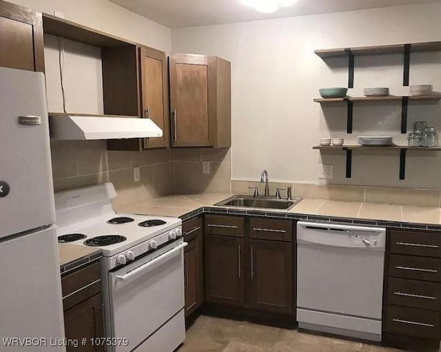 kitchen with tile countertops, dark brown cabinetry, white appliances, and sink