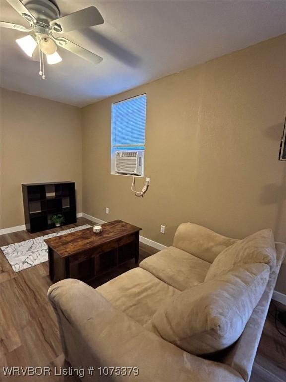 living room featuring ceiling fan, cooling unit, and dark wood-type flooring