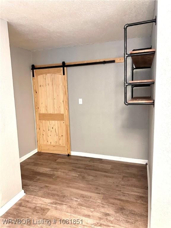 208 Cane Hill St, Van Buren, AR 72956 - spare room with wood finished floors, a textured ceiling, and a barn door