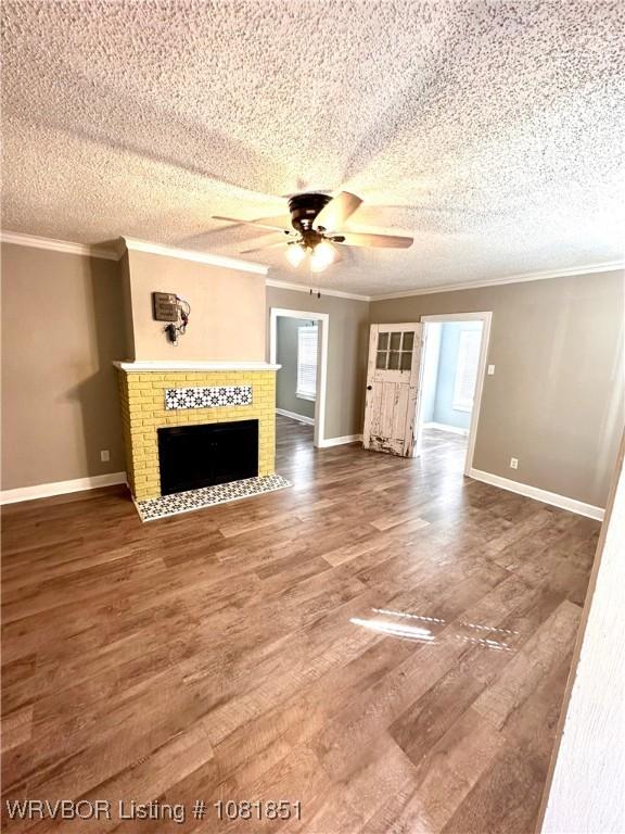 208 Cane Hill St, Van Buren, AR 72956 - unfurnished living room featuring ornamental molding, ceiling fan, wood finished floors, a brick fireplace, and a textured ceiling