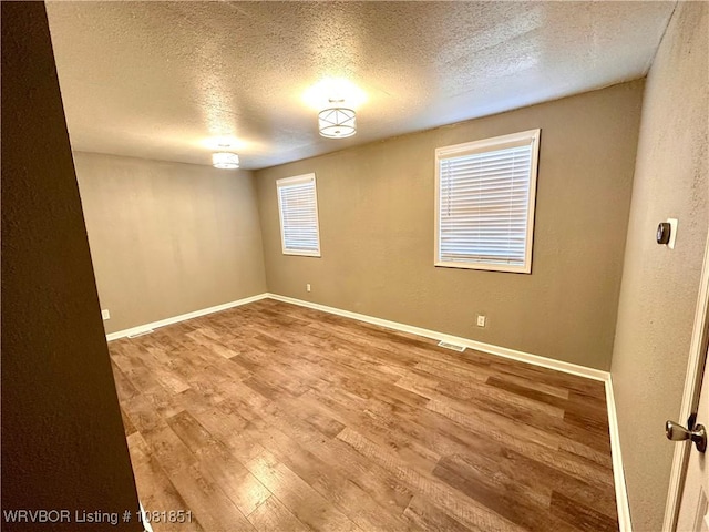 208 Cane Hill St, Van Buren, AR 72956 - empty room with a textured ceiling, wood finished floors, and a textured wall