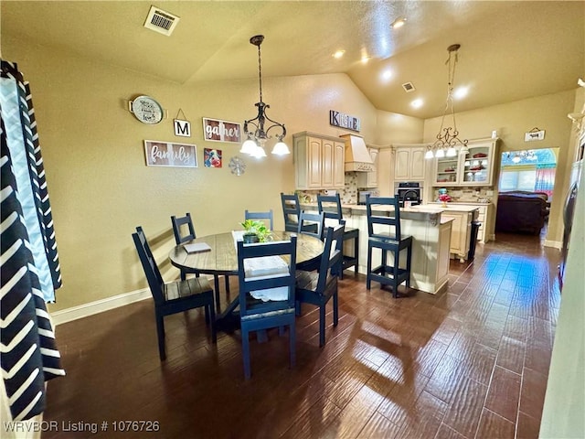 dining space featuring a chandelier, dark hardwood / wood-style flooring, and vaulted ceiling