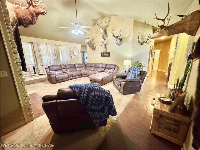 living room featuring ceiling fan, light wood-type flooring, and vaulted ceiling