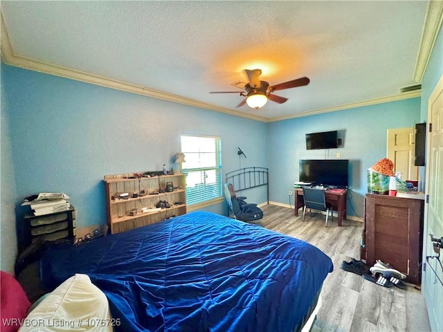 bedroom featuring ceiling fan, crown molding, a textured ceiling, and light wood-type flooring