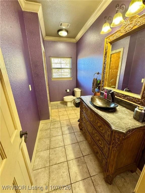 bathroom featuring tile patterned floors, vanity, toilet, and crown molding