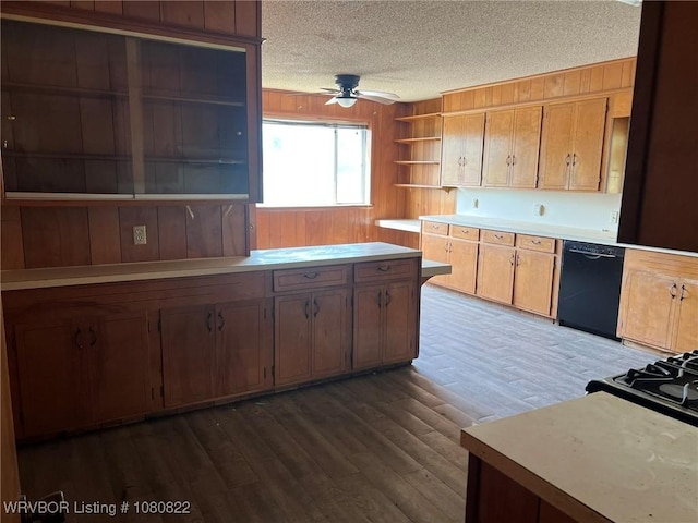 kitchen featuring a textured ceiling, open shelves, dishwasher, wooden walls, and a ceiling fan