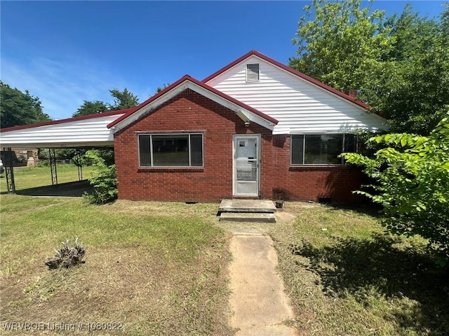 bungalow-style house featuring a front lawn, brick siding, and a carport