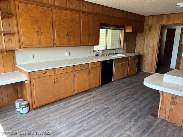 kitchen featuring black dishwasher, wood walls, wood finished floors, brown cabinets, and light countertops