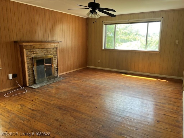 unfurnished living room with a ceiling fan, a brick fireplace, hardwood / wood-style floors, and baseboards