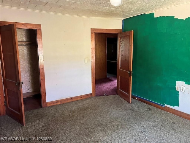 unfurnished bedroom featuring carpet flooring and baseboards