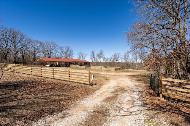 view of road with a rural view, driveway, and a gated entry