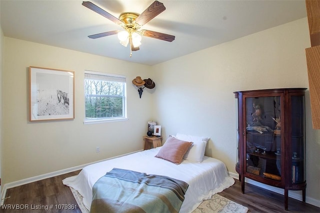 bedroom featuring wood finished floors, a ceiling fan, and baseboards