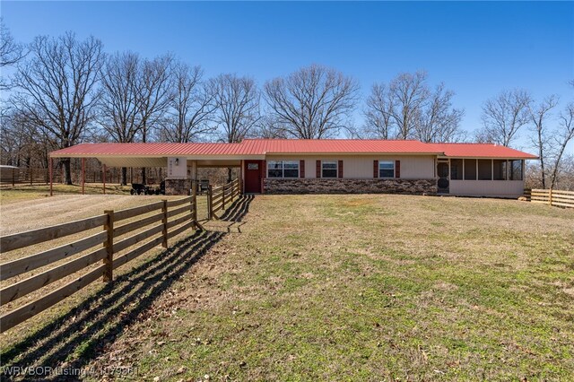 ranch-style home featuring a carport, driveway, metal roof, and a sunroom