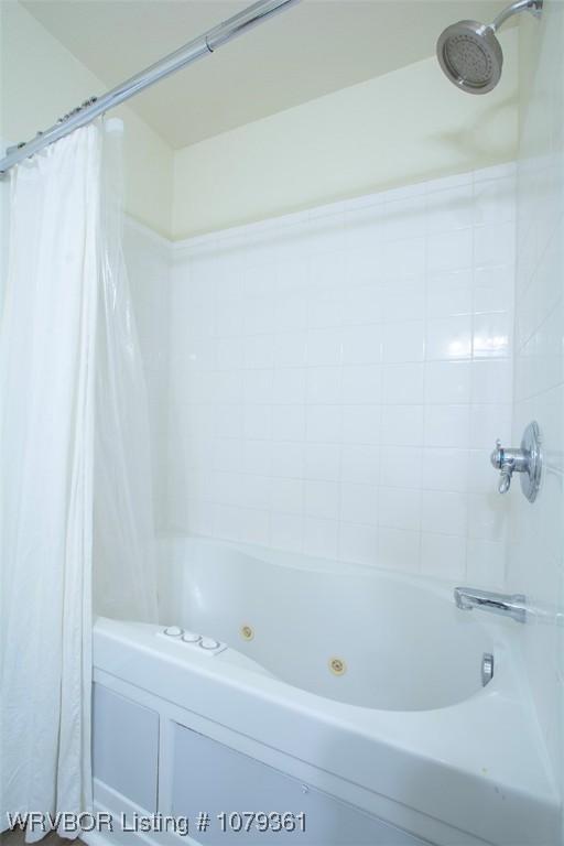 bathroom with a combined bath / shower with jetted tub