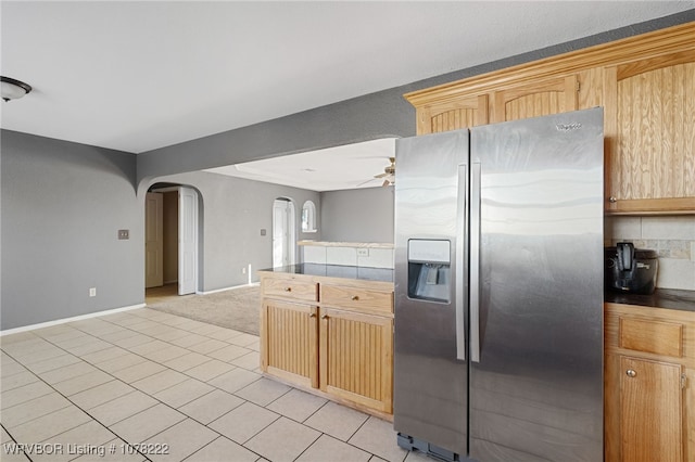 kitchen featuring ceiling fan, stainless steel fridge, and light brown cabinetry