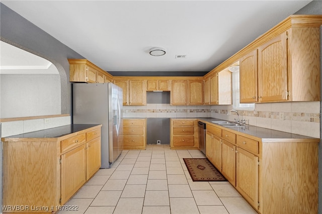 kitchen featuring light brown cabinets, backsplash, sink, light tile patterned floors, and stainless steel appliances