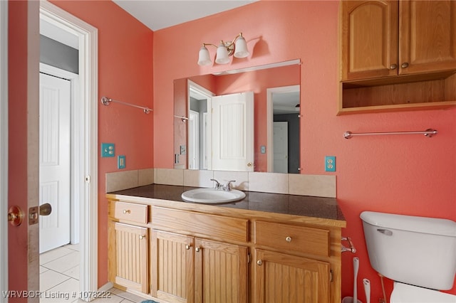 bathroom featuring tile patterned flooring, vanity, and toilet