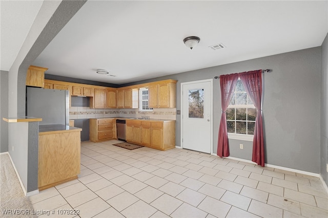 kitchen featuring appliances with stainless steel finishes, backsplash, sink, light tile patterned floors, and light brown cabinets