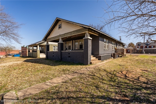 view of side of home with brick siding, crawl space, a lawn, and central AC unit