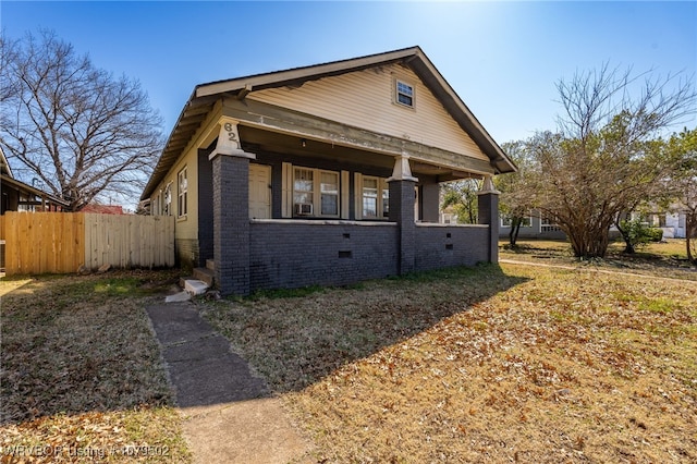 bungalow-style home featuring fence, brick siding, and crawl space