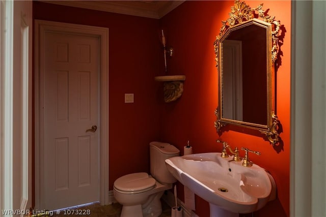 bathroom featuring toilet, ornamental molding, and sink