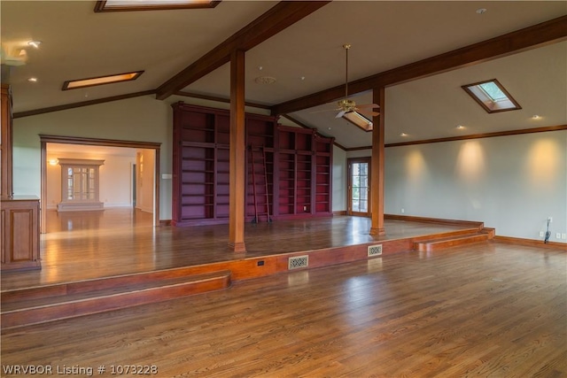 unfurnished living room featuring ceiling fan, vaulted ceiling with skylight, and hardwood / wood-style flooring