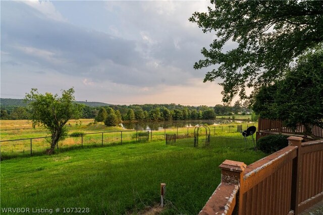 yard at dusk featuring a rural view