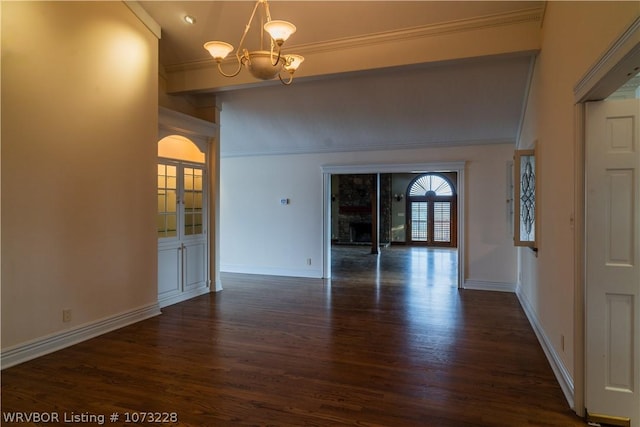 unfurnished dining area with a fireplace, dark hardwood / wood-style flooring, an inviting chandelier, and ornamental molding