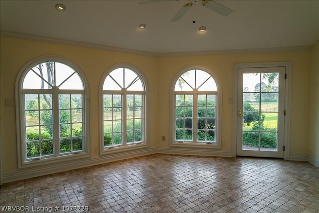 unfurnished sunroom featuring ceiling fan