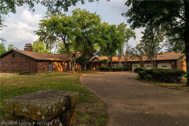 single story home with a garage and a front lawn