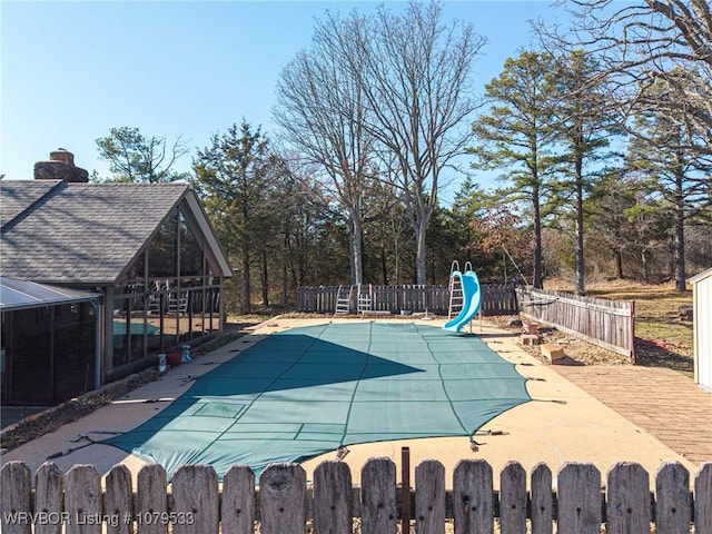 view of swimming pool featuring a fenced in pool, a patio, a water slide, and a fenced backyard