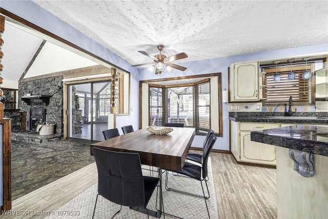 dining space featuring a healthy amount of sunlight, light wood finished floors, and a textured ceiling