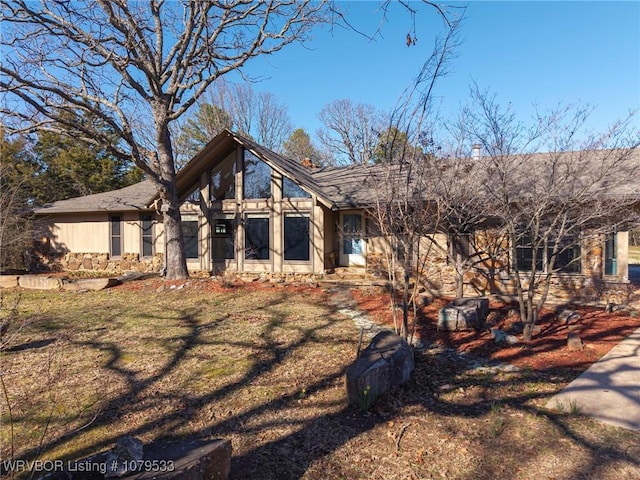 view of front of property with stone siding and a front yard