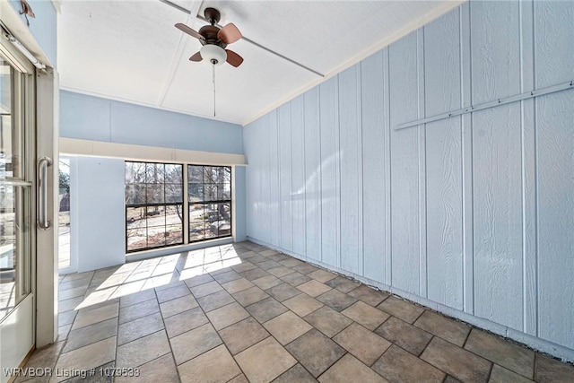 unfurnished room with wood walls and ceiling fan