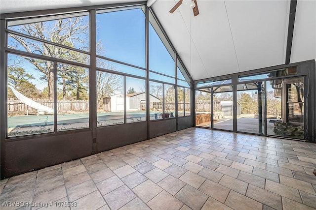 unfurnished sunroom featuring vaulted ceiling with beams and ceiling fan